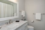 The en-suite bathroom has a single vanity with a shower tub combo